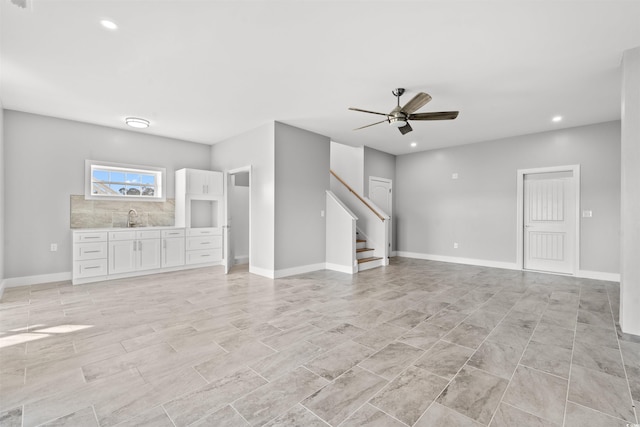 unfurnished living room with ceiling fan and sink