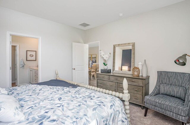 bedroom with light colored carpet and ensuite bath