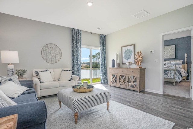 living room with a water view and wood-type flooring