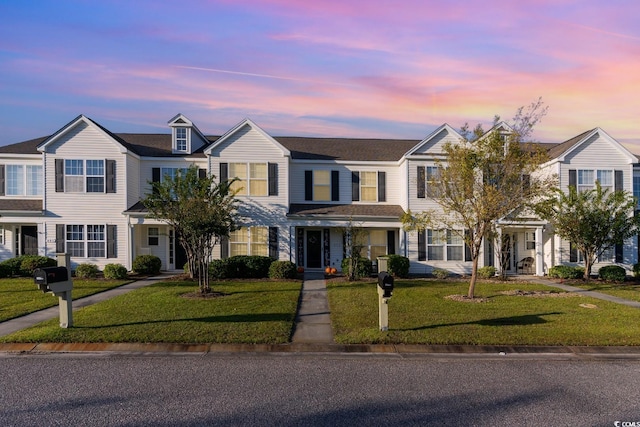 townhome / multi-family property with a front lawn