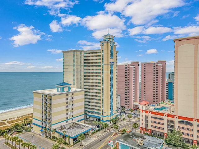 view of building exterior with a water view and a beach view