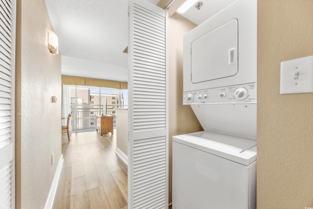 2504 N Ocean Blvd Unit 1736, Myrtle Beach, SC 29577 - washroom with stacked washer / dryer, a textured wall, light wood-type flooring, and baseboards