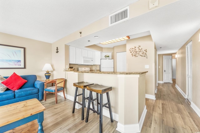 2504 N Ocean Blvd Unit 1736, Myrtle Beach, SC 29577 - kitchen featuring white appliances, light wood-style floors, baseboards, and a peninsula
