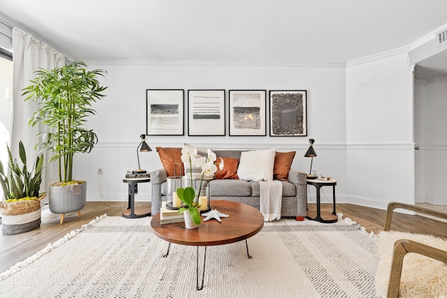 living room with crown molding and hardwood / wood-style floors