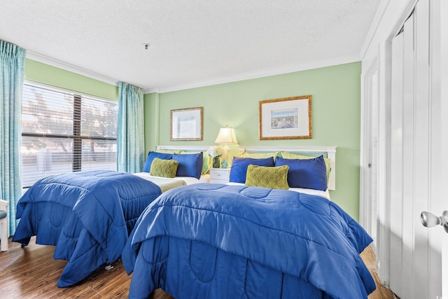 bedroom with a closet, crown molding, a textured ceiling, and hardwood / wood-style floors