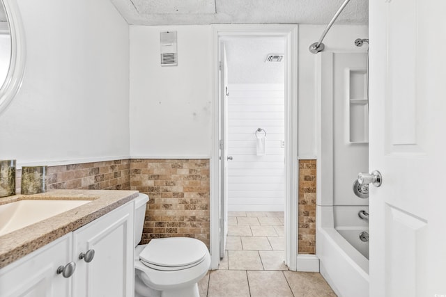 full bathroom featuring a textured ceiling, tile walls, toilet, vanity, and tile patterned flooring