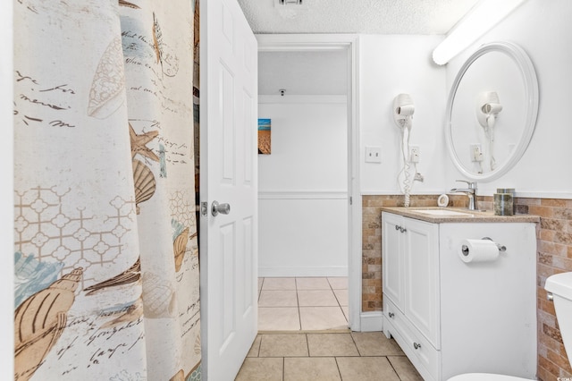 bathroom with vanity, a textured ceiling, toilet, and tile patterned floors