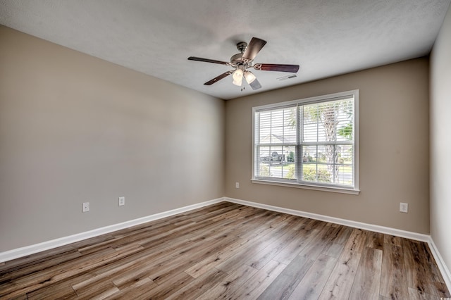 unfurnished room with a textured ceiling, light hardwood / wood-style floors, and ceiling fan