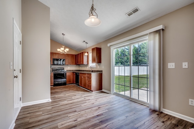 kitchen featuring black appliances, decorative light fixtures, light hardwood / wood-style floors, and sink