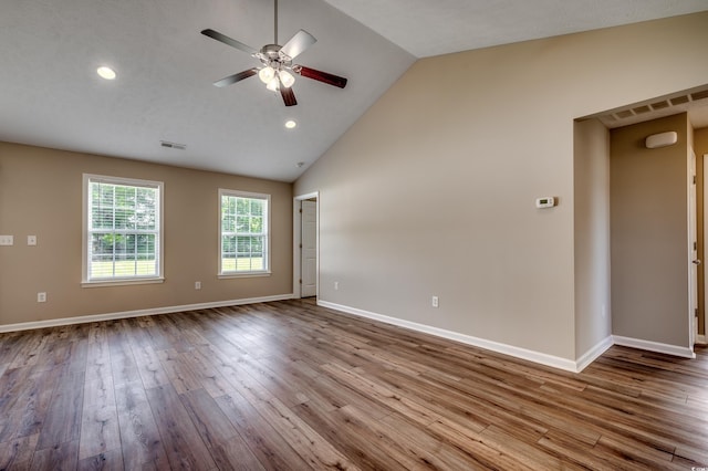 empty room featuring ceiling fan, high vaulted ceiling, light hardwood / wood-style floors, and a textured ceiling