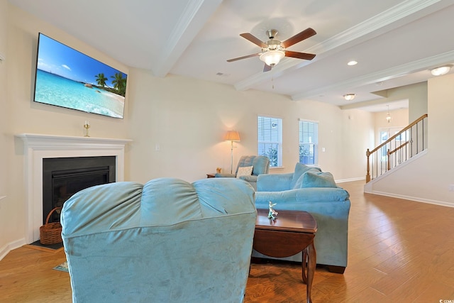 living room with ceiling fan, beamed ceiling, crown molding, and light hardwood / wood-style floors