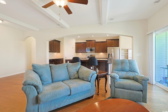 living room featuring beam ceiling, light wood-type flooring, and ceiling fan