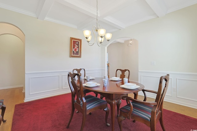 dining space with crown molding, beam ceiling, and hardwood / wood-style flooring