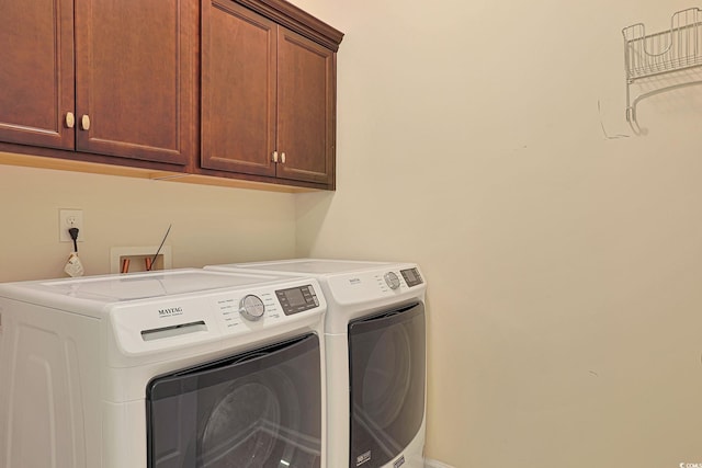 laundry area featuring cabinets and washing machine and dryer