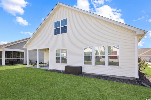 back of property with a patio area and a lawn