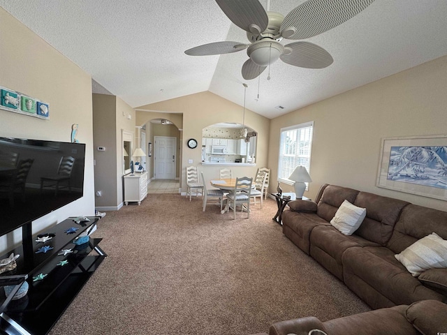 carpeted living room with ceiling fan, a textured ceiling, and vaulted ceiling