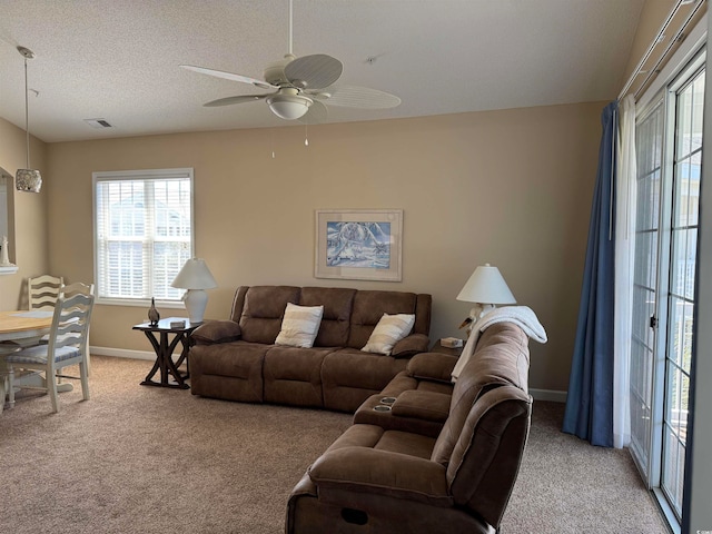 carpeted living room with ceiling fan and a textured ceiling