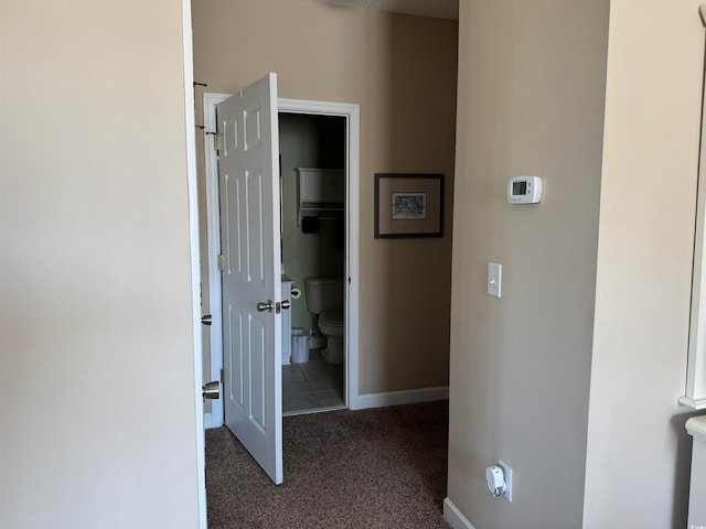 hallway featuring dark carpet