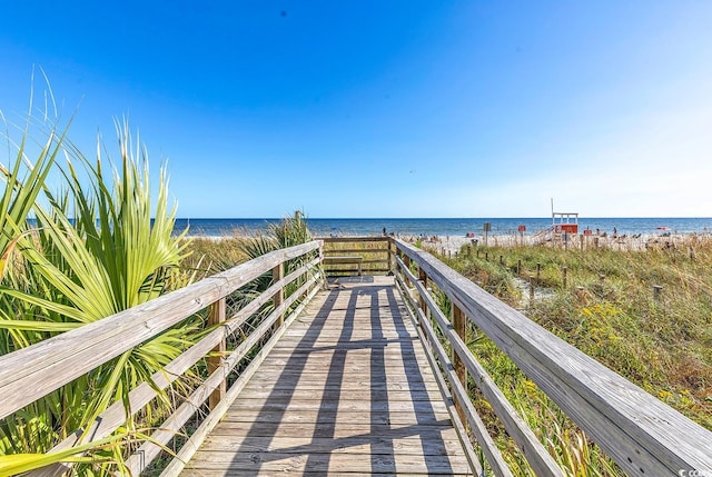 surrounding community featuring a water view and a beach view