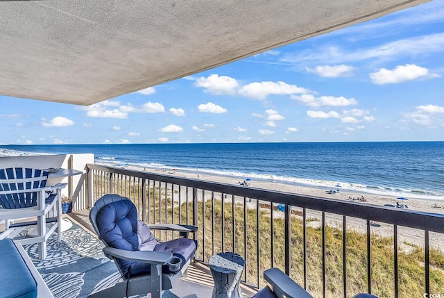 balcony featuring a water view and a beach view