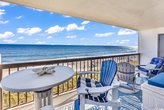 balcony with a water view and a beach view