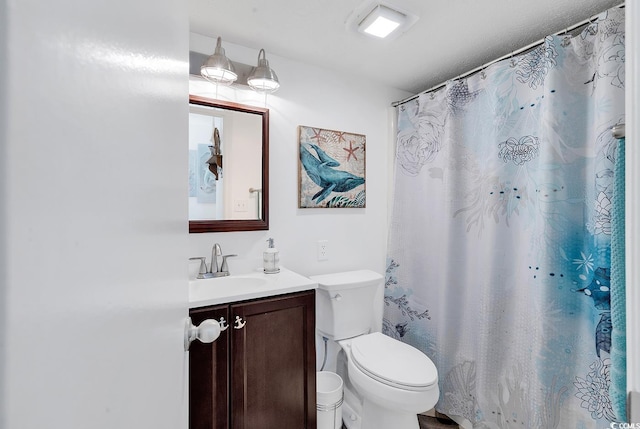 bathroom with a shower with shower curtain, vanity, and toilet