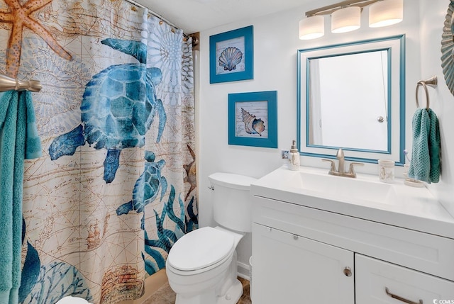 bathroom featuring vanity, toilet, and curtained shower