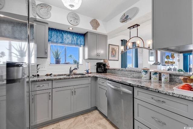 kitchen featuring sink, gray cabinetry, dishwasher, dark stone countertops, and a notable chandelier