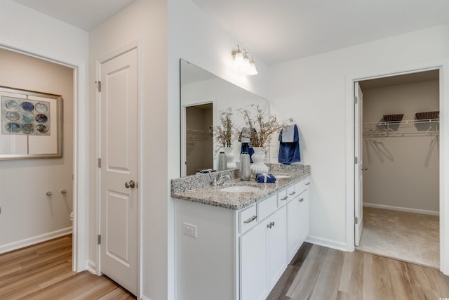 bathroom with wood-type flooring, vanity, and toilet