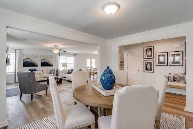 dining area featuring light hardwood / wood-style floors, ceiling fan, and crown molding