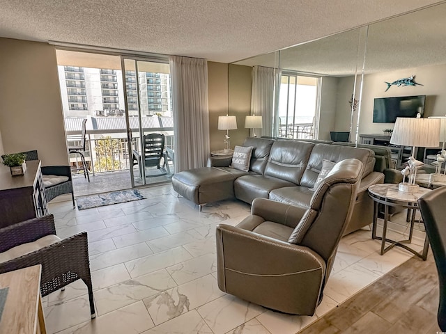 living room with a textured ceiling and floor to ceiling windows