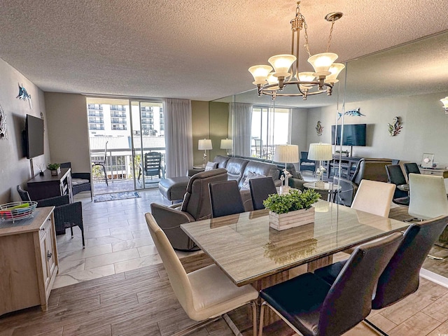 dining area with light hardwood / wood-style floors, a notable chandelier, and a textured ceiling