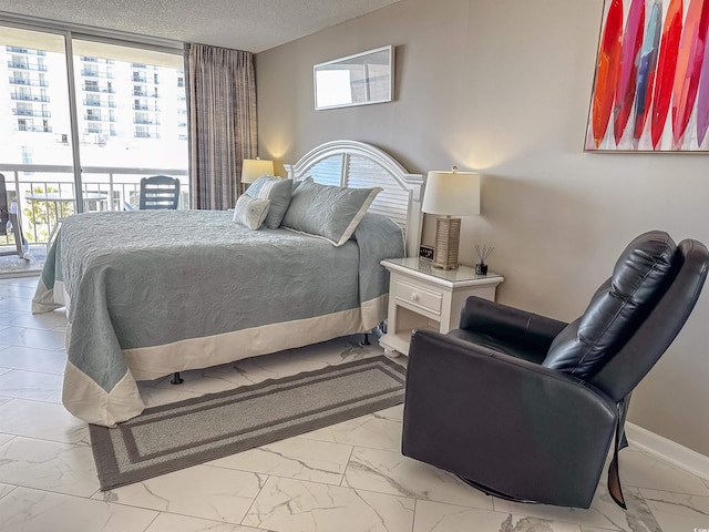 bedroom with access to outside and a textured ceiling