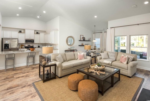 living room featuring lofted ceiling and light wood-type flooring