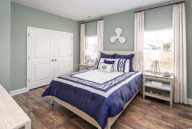 bedroom with dark wood-type flooring and a closet