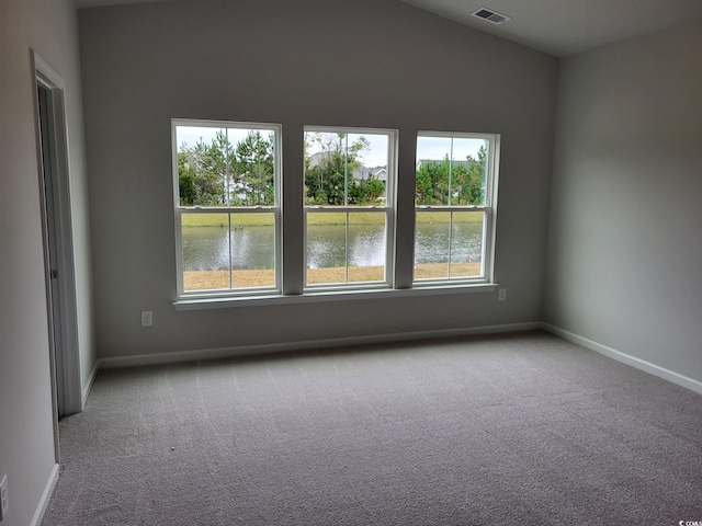 carpeted spare room featuring a water view and a wealth of natural light