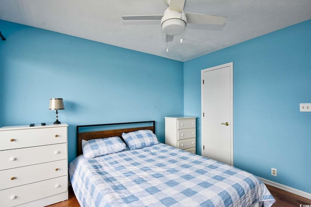 bedroom featuring ceiling fan, hardwood / wood-style flooring, and a textured ceiling