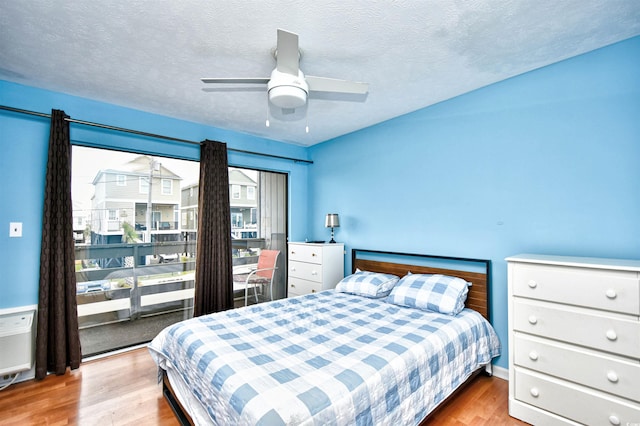 bedroom featuring light wood-type flooring, ceiling fan, and a textured ceiling