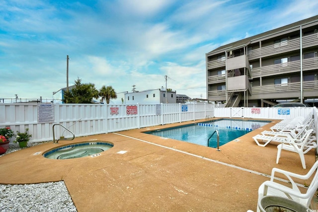 community pool with fence, a community hot tub, and a patio