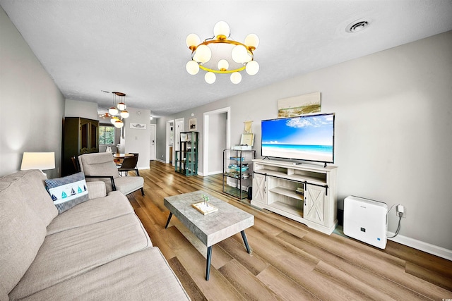 living room with a notable chandelier, hardwood / wood-style floors, and a textured ceiling