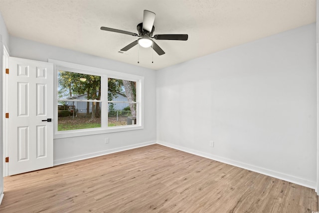 empty room with light hardwood / wood-style floors, a textured ceiling, and ceiling fan