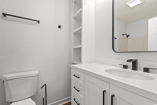 bathroom featuring vanity, a textured ceiling, a shower, and toilet