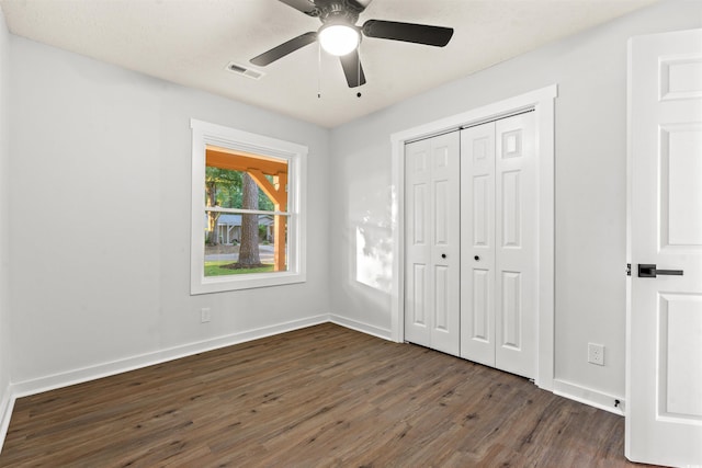 unfurnished bedroom featuring a closet, dark hardwood / wood-style flooring, and ceiling fan