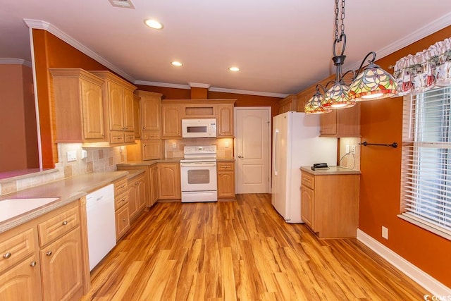 kitchen with pendant lighting, vaulted ceiling, white appliances, and a wealth of natural light