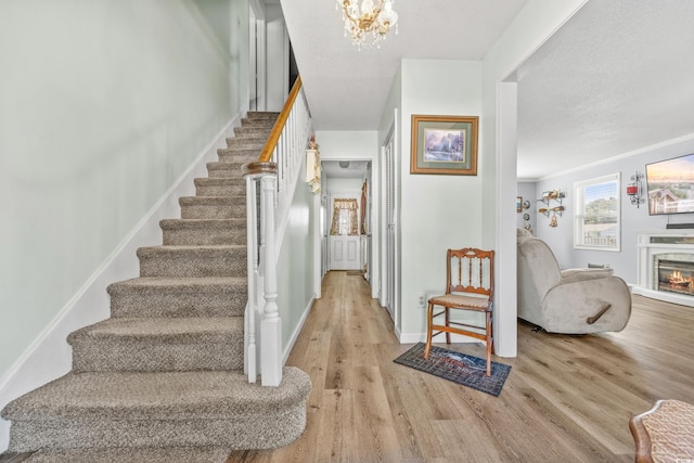 foyer with light hardwood / wood-style floors, a chandelier, and a textured ceiling