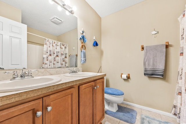 bathroom with tile patterned flooring, vanity, toilet, and walk in shower