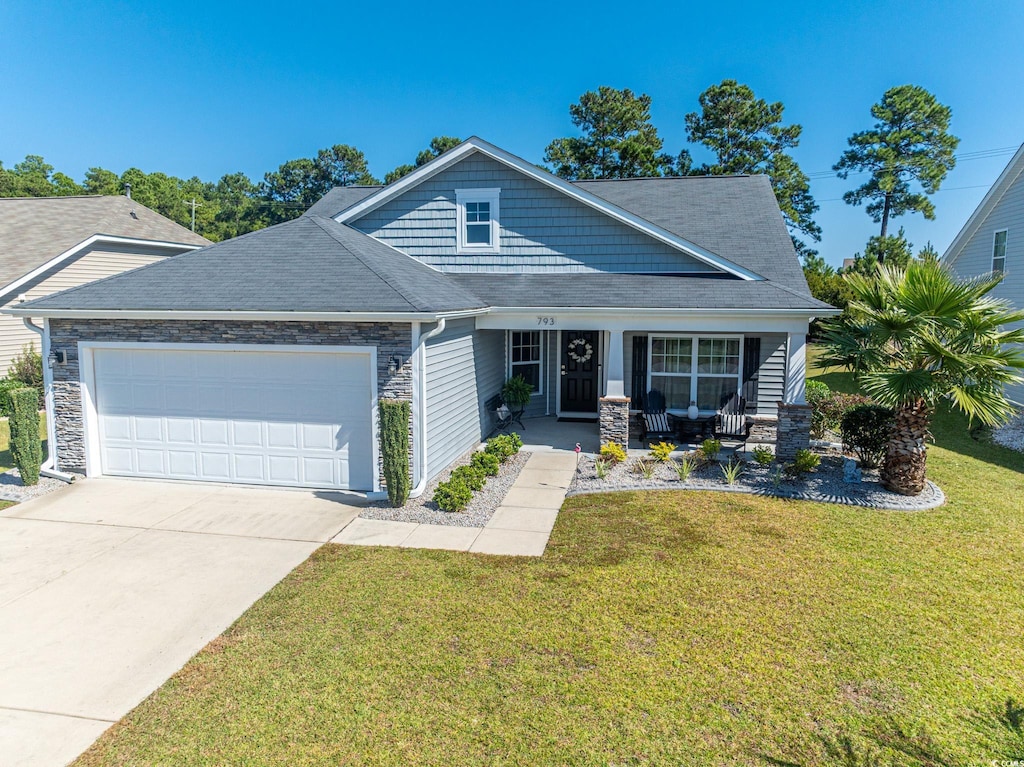 view of front of property with a front lawn, covered porch, and a garage