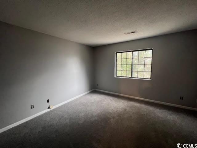 carpeted spare room featuring a textured ceiling