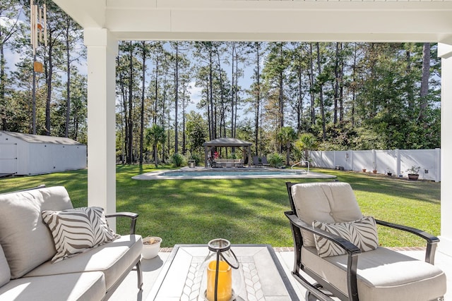 view of yard with a gazebo, a shed, a patio area, a fenced in pool, and an outdoor living space