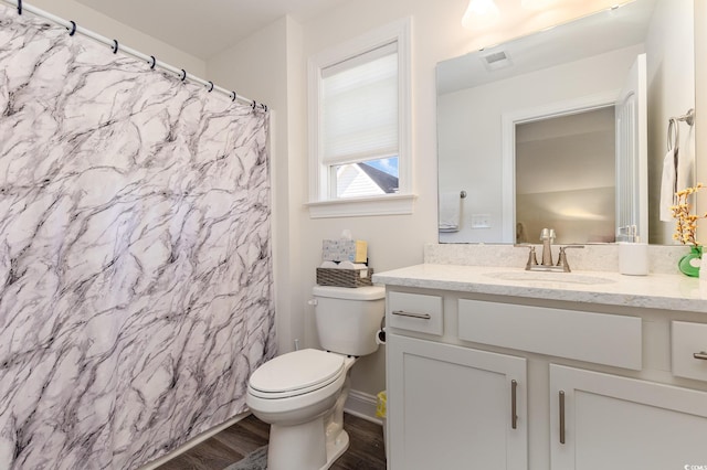 bathroom with toilet, hardwood / wood-style flooring, and vanity